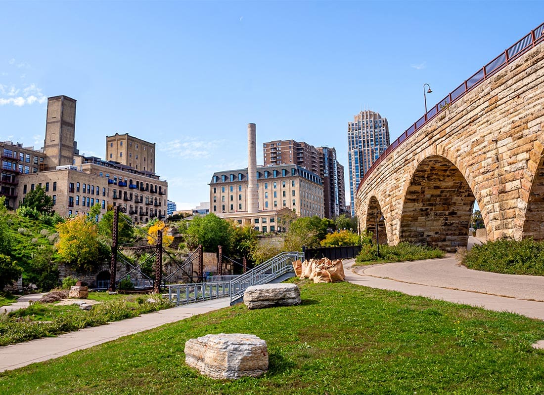 Minneapolis, MN - Minneapolis Downtown Skyline Viewing Besides Stone Arch Bridge Under a Sunny Day